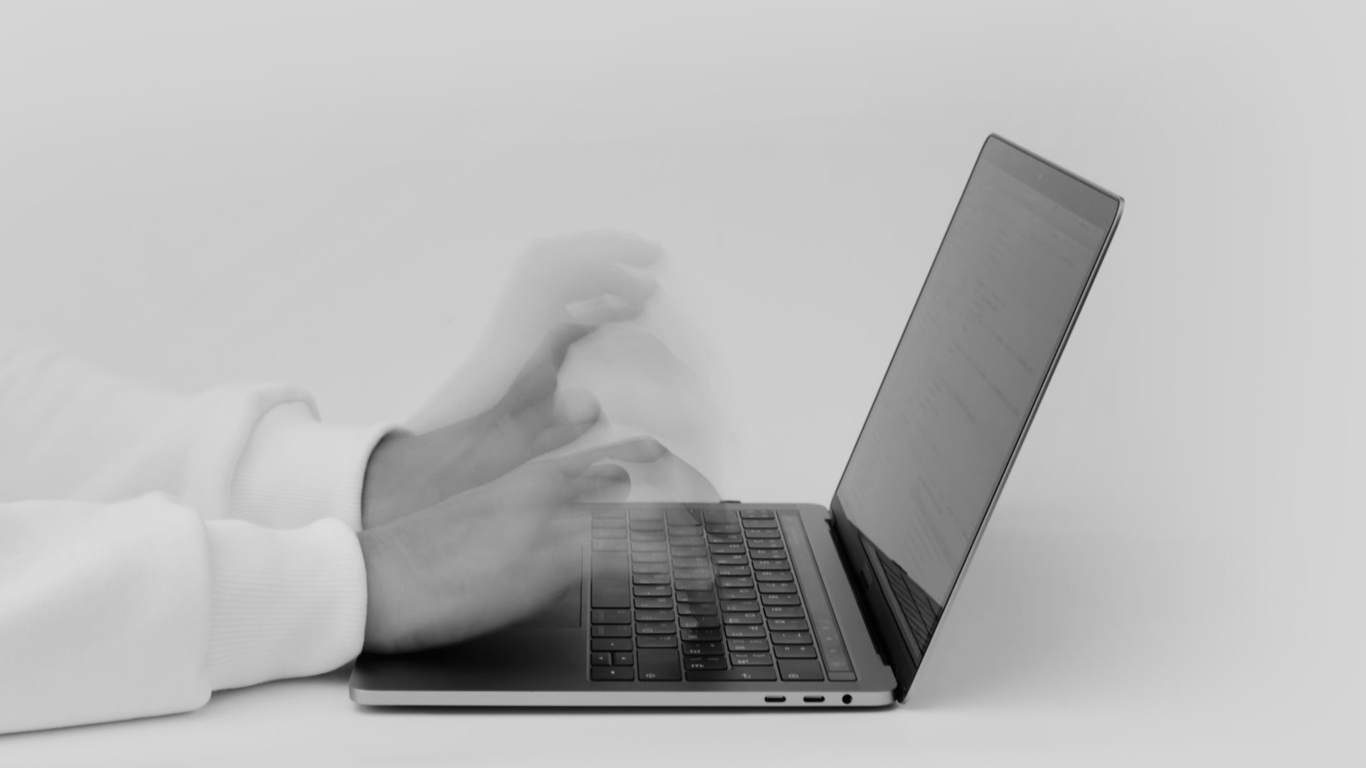 Hands over laptop typing fast.